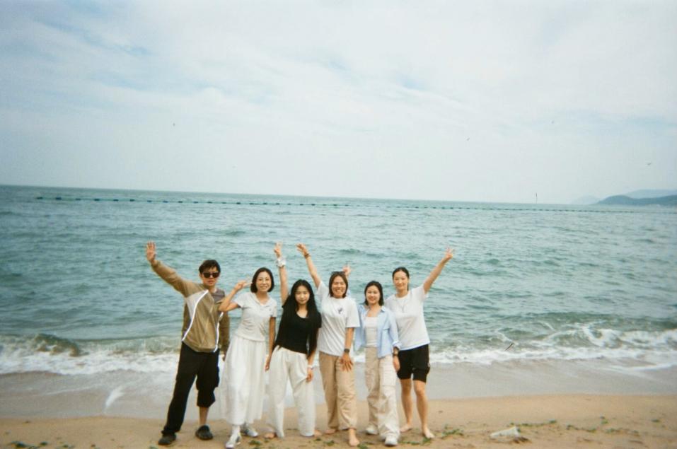 Wenxiu Wei and friends standing together by the sea