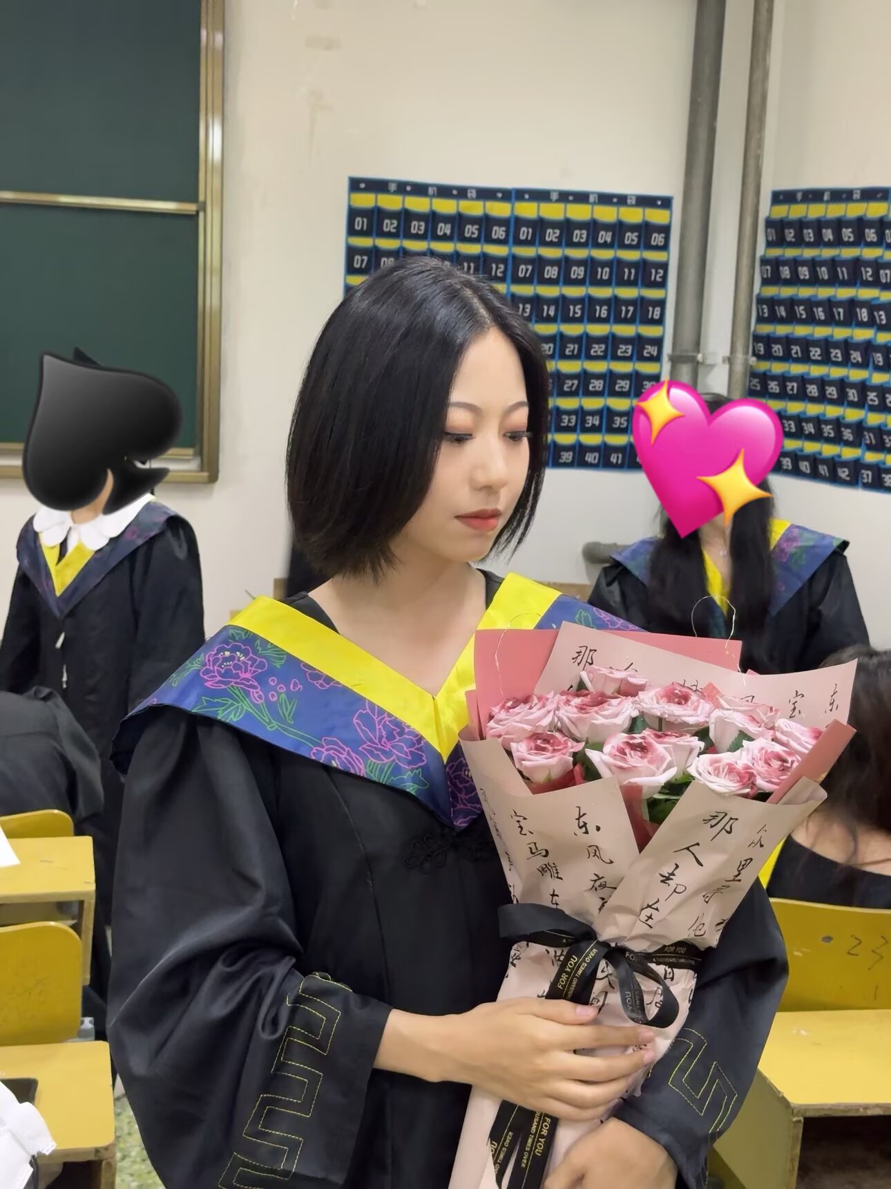 Wenxiu Wei in graduation attire holding a bouquet